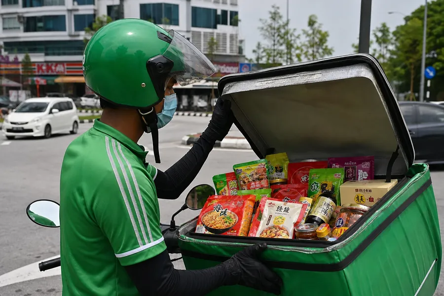 骑手载着装满食品的配送箱在吉隆坡街道上送货